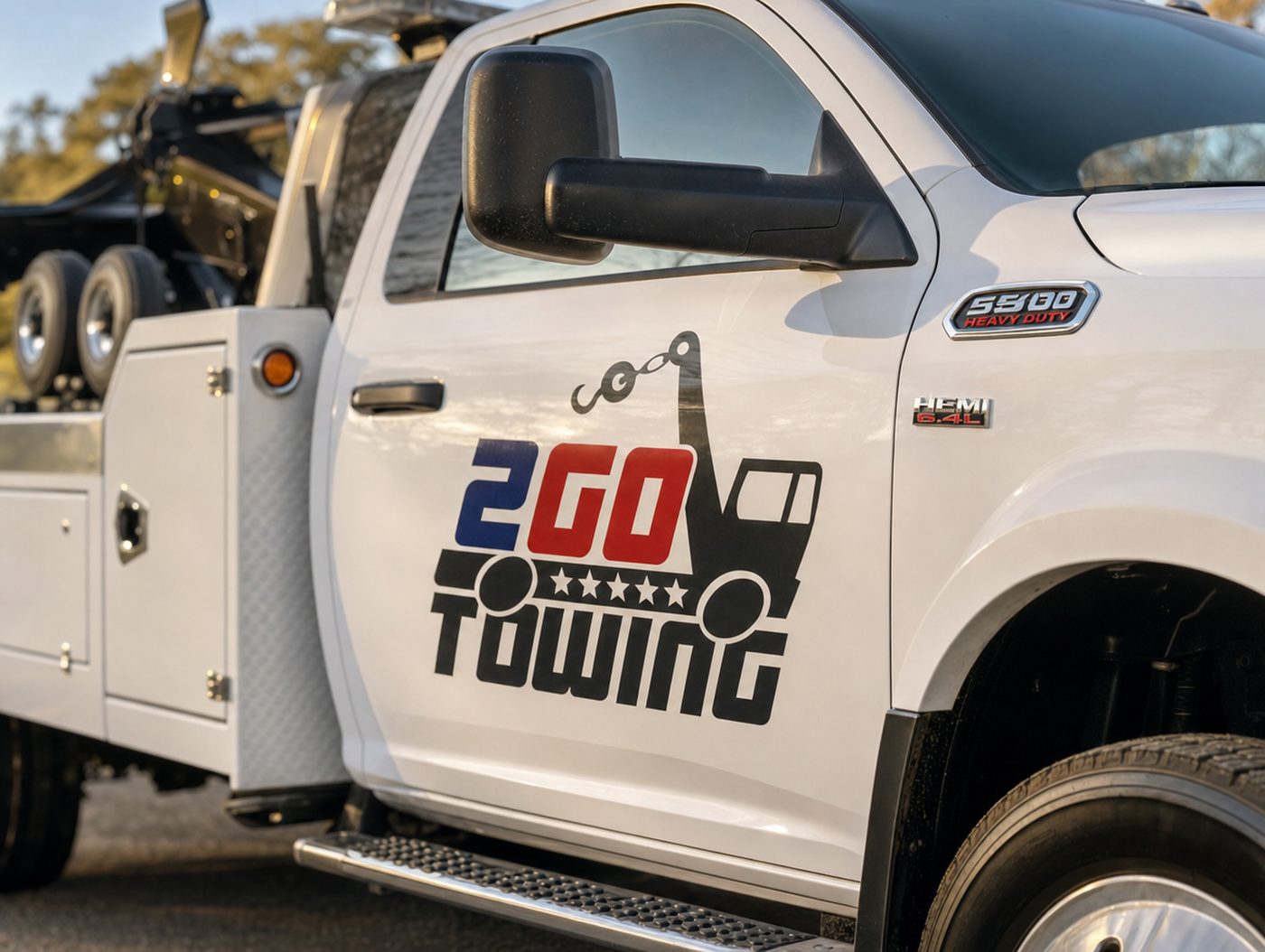 Close-up of the Auto Towing 2Go logo decal on the driver door of the company's tow truck